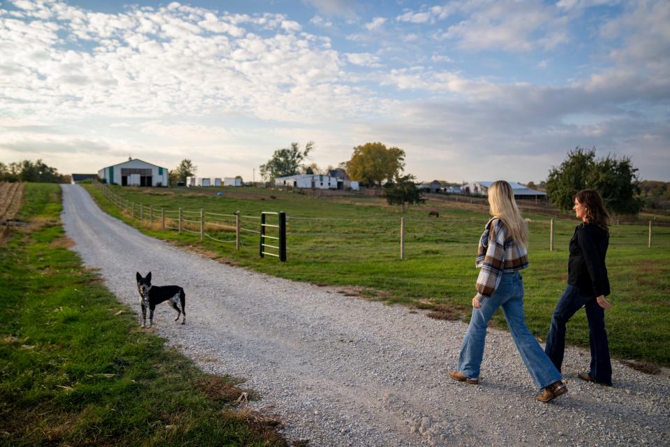 Elivia Papcun and her mother, Dawn, walk to the barn on their property.
