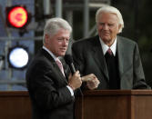 <p>Former president Bill Clinton, left, speaks alongside the Rev. Billy Graham on the second night of the Greater New York Billy Graham Crusade, June 25, 2005, at Flushing Meadows’ Corona Park in the New York borough of Queens. (Photo: Frank Franklin II/AP) </p>