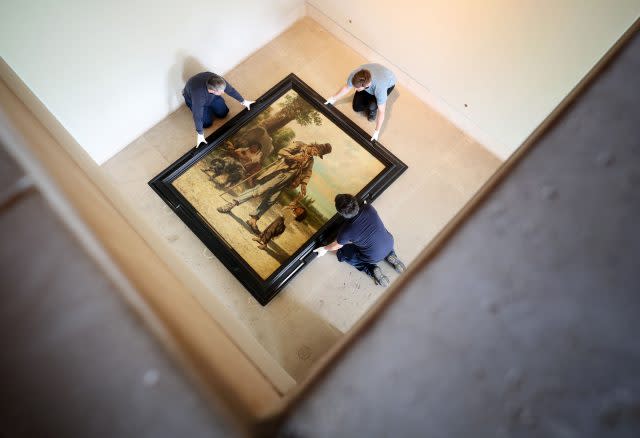 Art technicians Andy Cavanagh, Angus Wolf and Paul McCall help to move The Beggar at Ornans by French Realist Gustave Courbet, one of the most recognisable paintings at the Burrell Collection (Jane Barlow/PA)