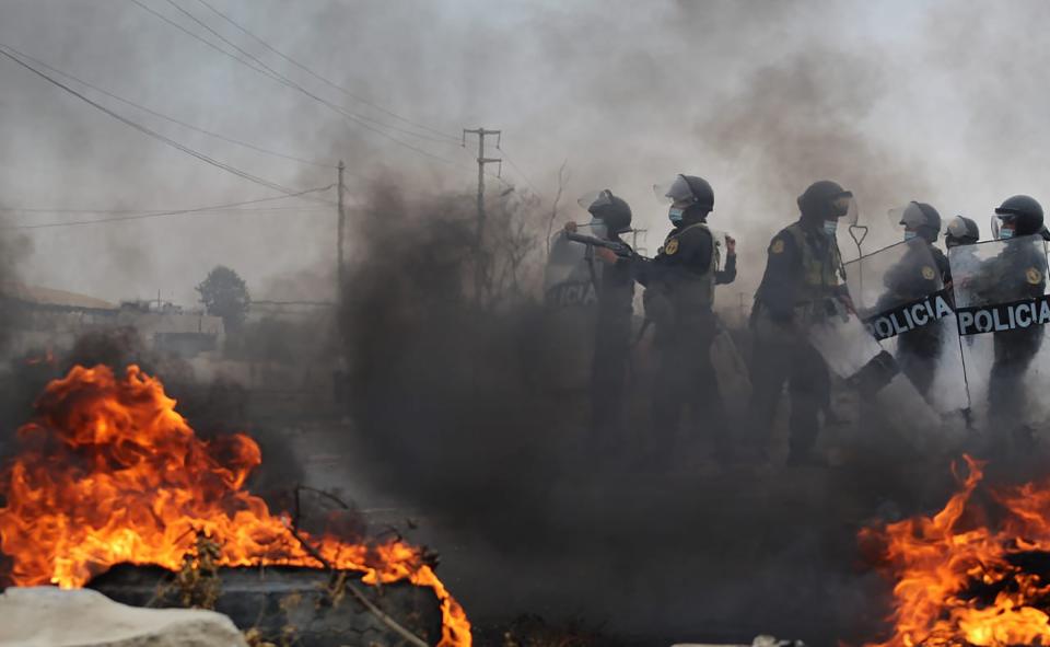 La policía antidisturbios llega a un bloqueo establecido por trabajadores agrícolas en un tramo de la Carretera Panamericana Sur, al norte de Lima, Perú, el miércoles 30 de diciembre de 2020. (AP Foto/Elmer Caceres)