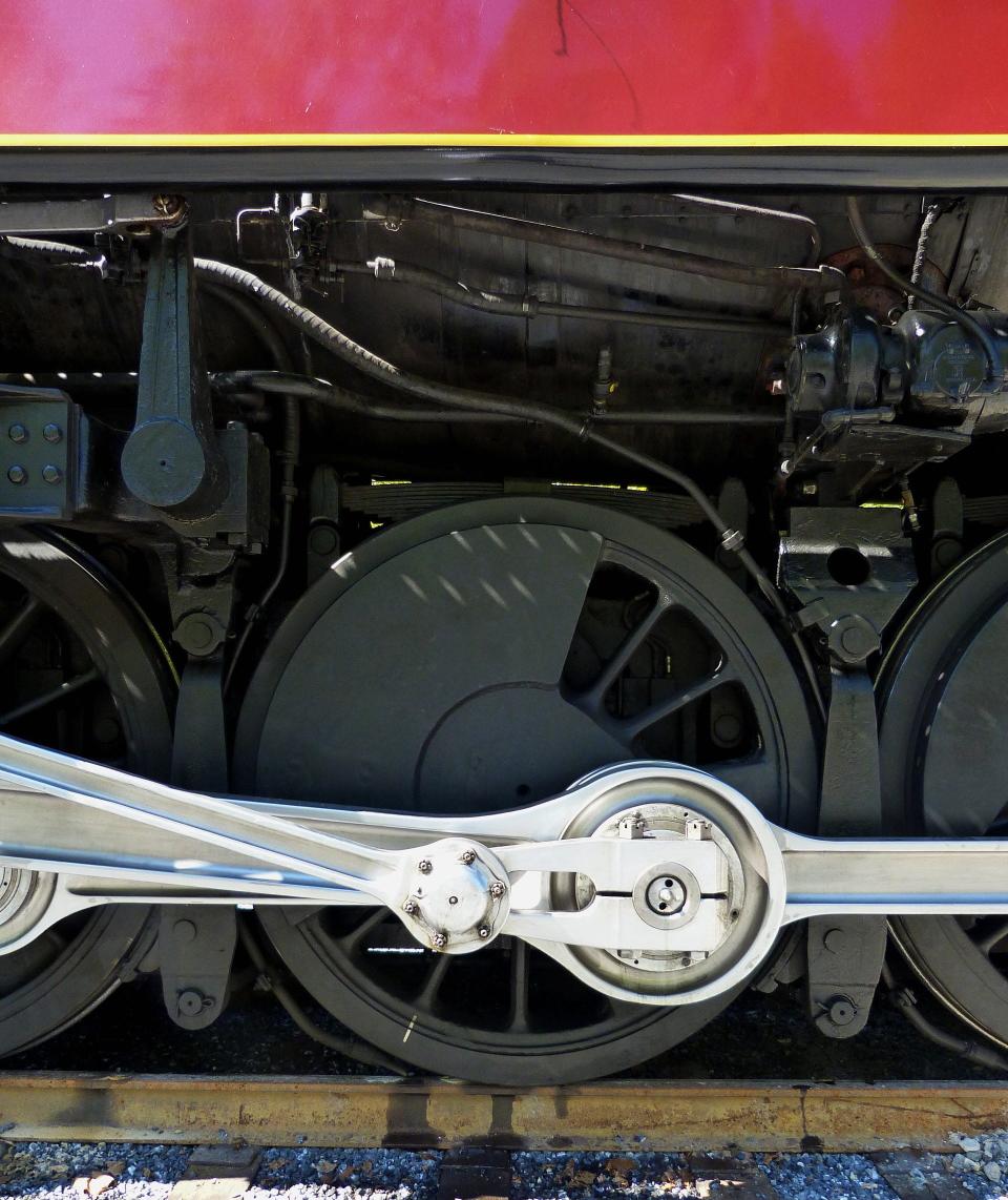 One of the eight massive driving wheels that stands more than five feet tall is framed by the Tuscan red and gold livery that graced the pinnacle of steam technology in the 1950s.