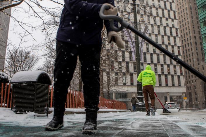 Ashcraft Landscape workers shovel snow in downtown Detroit near Woodward Ave. on Monday Jan. 24, 2022. Areas of Michigan including Detroit received fresh snowfall during the night.