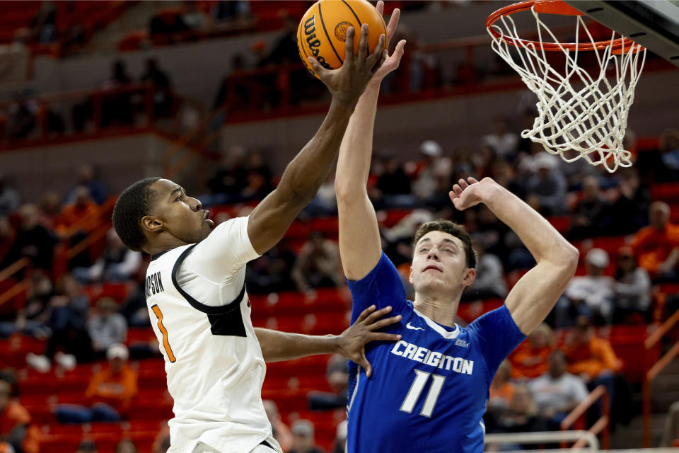 Oklahoma State guard Bryce Thompson (1) shoots a layup over Creighton center Ryan Kalkbrenner (11) in the second half of an NCAA college basketball game, Thursday, Nov. 30, 2023, in Stillwater, Okla. (AP Photo/Mitch Alcala)