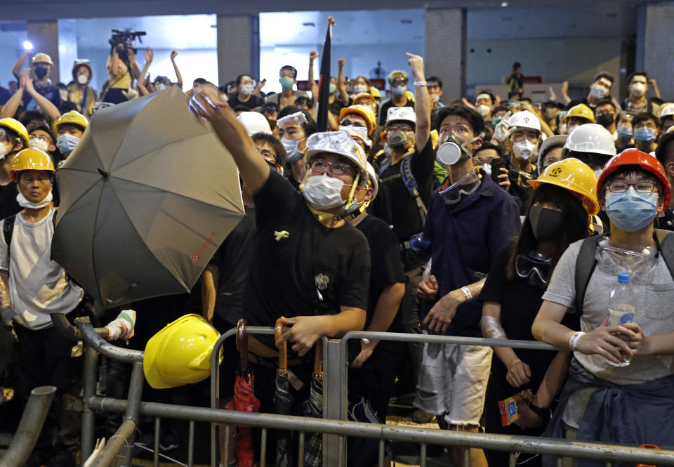 A protester throws eggs at the police headquarter in Hong Kong, Friday, June 21, 2019. Several hundred protesters, mainly students, gathered Friday outside Hong Kong government offices and police headquarter with some blocking traffic on a major thoroughfare and others occupying the lobby of a government tax office. (AP Photo/Vincent Yu)