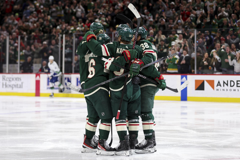 Minnesota Wild left wing Kirill Kaprizov is congratulated for his goal by left wing Matt Boldy, right wing Mats Zuccarello and right wing Ryan Hartman during the third period of an NHL hockey game against the Vancouver Canucks, Monday, Feb. 19, 2024, in St. Paul, Minn. (AP Photo/Matt Krohn)