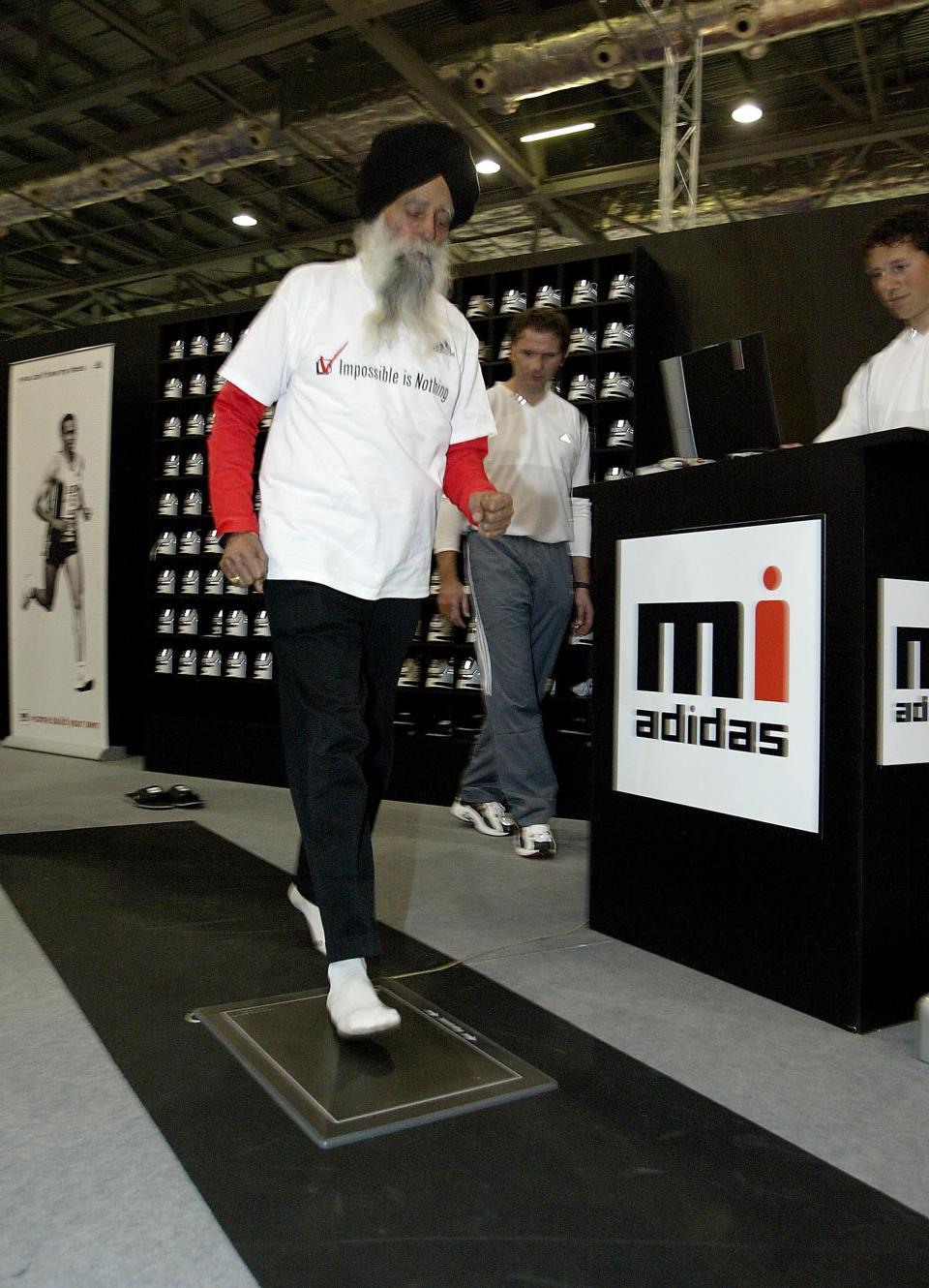 LONDON, ENGLAND - APRIL 15: Fauja Singh, 93 and the oldest competing runner in the London Marathon, designs his own shoe at the Adidas stand at the Marathon Exhibition being held at the Excel Centre on April 15, 2004 in London. (Photo by John Gichigi/Getty Images for adidas) 