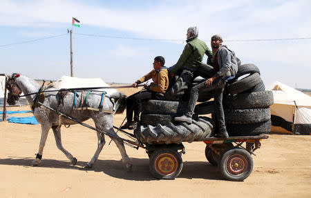 Palestinian activists collect tyres to be burnt along Israel-Gaza border, in the southern Gaza Strip April 2, 2018. Picture taken April 2, 2018. REUTERS/Ibraheem Abu Mustafa