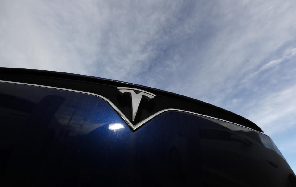 FILE - In this Nov. 10, 2019, file photo the company logo shines off the grille of an unsold 2020 Model X at a Tesla dealership in Littleton, Colo. Tesla reports financial results on Wednesday, Jan. 29, 2020. (AP Photo/David Zalubowski, File)