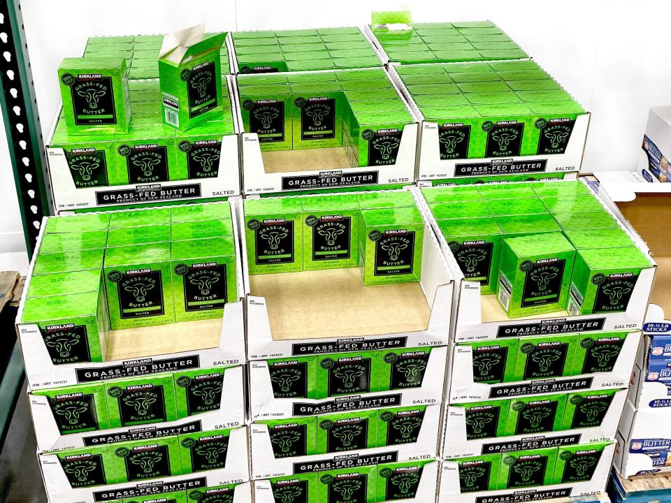 Bright-green boxes of Kirkland Signature grass-fed butter in white cardboard boxes at Costco