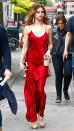 <p>Gomez hit the streets of New York City in an eye-catching red satin dress and metallic heels. Statement earrings and a coordinating cuff finished off her dazzling look.</p>