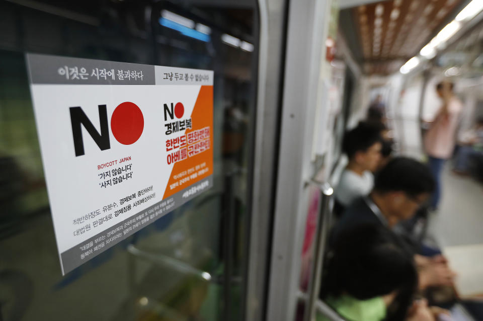A notice campaigning for a boycott of Japanese-made products is displayed in a subway train in Seoul, South Korea, Thursday, Aug. 1, 2019. Lawmakers from Japan and South Korea met Wednesday in a bid to ease their countries' worsening dispute over trade and history, but after hugs and smiles at the beginning, they ended up repeating their demands to each other. The notice reads: "Economic retaliation and We denounce Japanese Prime Minister Shinzo Abe." (AP Photo/Ahn Youg-joon)