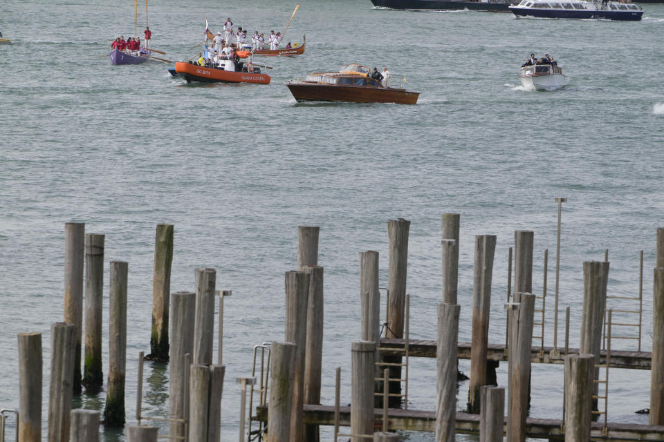 Pope Francis, aboard of a speedboat foreground, is greeted by Gondoliers upon his arrival in Venice, Italy, Sunday, April 28, 2024. The Pontiff arrived for his first-ever visit to the lagoon town including the Vatican pavilion at the 60th Biennal of Arts. (AP Photo/Alessandra Tarantino)