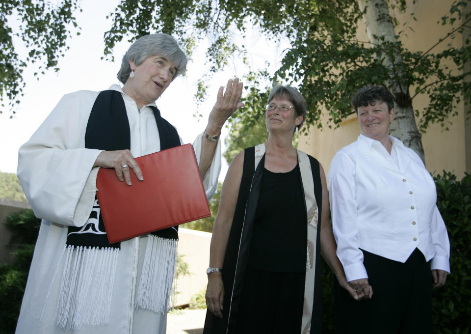 FILE - The Reverend Dr. Jane Spahr, left, a Presbyterian minister, performs a same-sex marriage for Sherrie Holmes, center, and Sara Taylor, right, at the Marin Civic Center in San Rafael, Calif., Friday, June 20, 2008. When the United Methodist Church removed anti-LGBTQ language from its official rules in recent days, it marked the end of a half-century of debates over LGBTQ inclusion in mainline Protestant denominations. The moves sparked joy from progressive delegates, but the UMC faces many of the same challenges as Lutheran, Presbyterian and Episcopal denominations that took similar routes, from schisms to friction with international churches to the long-term aging and shrinking of their memberships. (AP Photo/Eric Risberg, File)