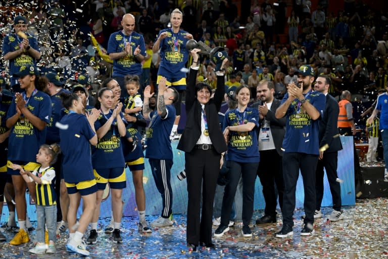 Valérie Garnier (au centre), coach de Fenerbahçe et ex-sélectionneuse de l'équipe de France de basket, brandit le trophée de l'Euroligue féminine après la victoire du club turc face à Villeneuve d'Ascq, le 14 avril 2024 à Mersin (OZAN KOSE)