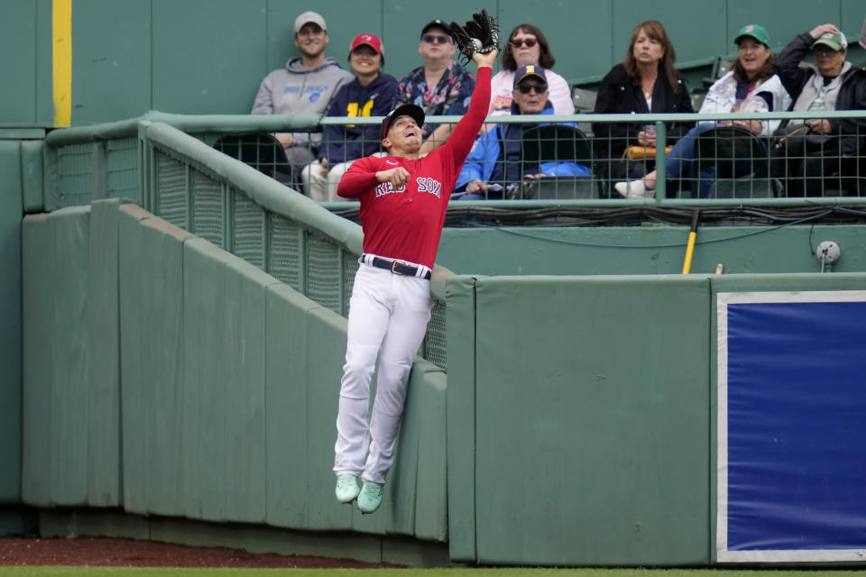 Boston Red Sox center fielder Enrique Hernandez leaps and makes a catch against the bullpen wall on a flyout by Tampa Bay Rays' Luke Raley during the second inning of a baseball game at Fenway Park, Monday, June 5, 2023, in Boston. (AP Photo/Charles Krupa)