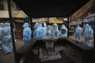 India health workers wearing personal protective equipment arrive to take part in a check up camp at a slum in Mumbai, India, Wednesday, June 17, 2020. India is the fourth hardest-hit country by the COVID-19 pandemic in the world after the U.S., Russia and Brazil. (AP Photo/Rafiq Maqbool)
