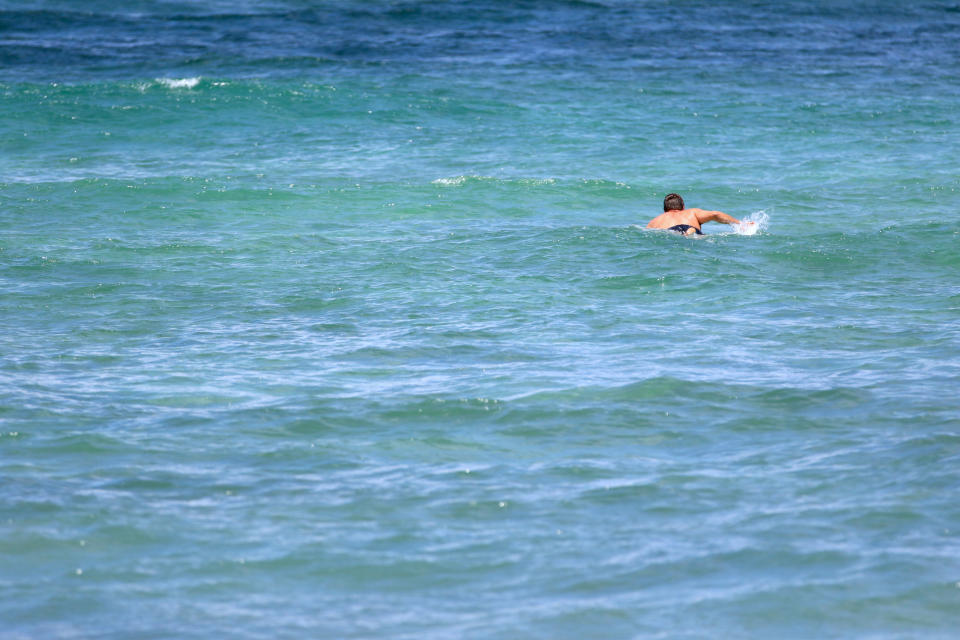 Isaiah Helekunihi Walker, a Native Hawaiian historian and professor, paddles out to surf in Laie, Hawaii, Thursday, July 8, 2021. For some Native Hawaiians, surfing’s Olympic debut is both a celebration of a cultural touchstone invented by their ancestors, and an extension of the racial indignities seared into the history of the game and their homeland. (AP Photo/Caleb Jones)