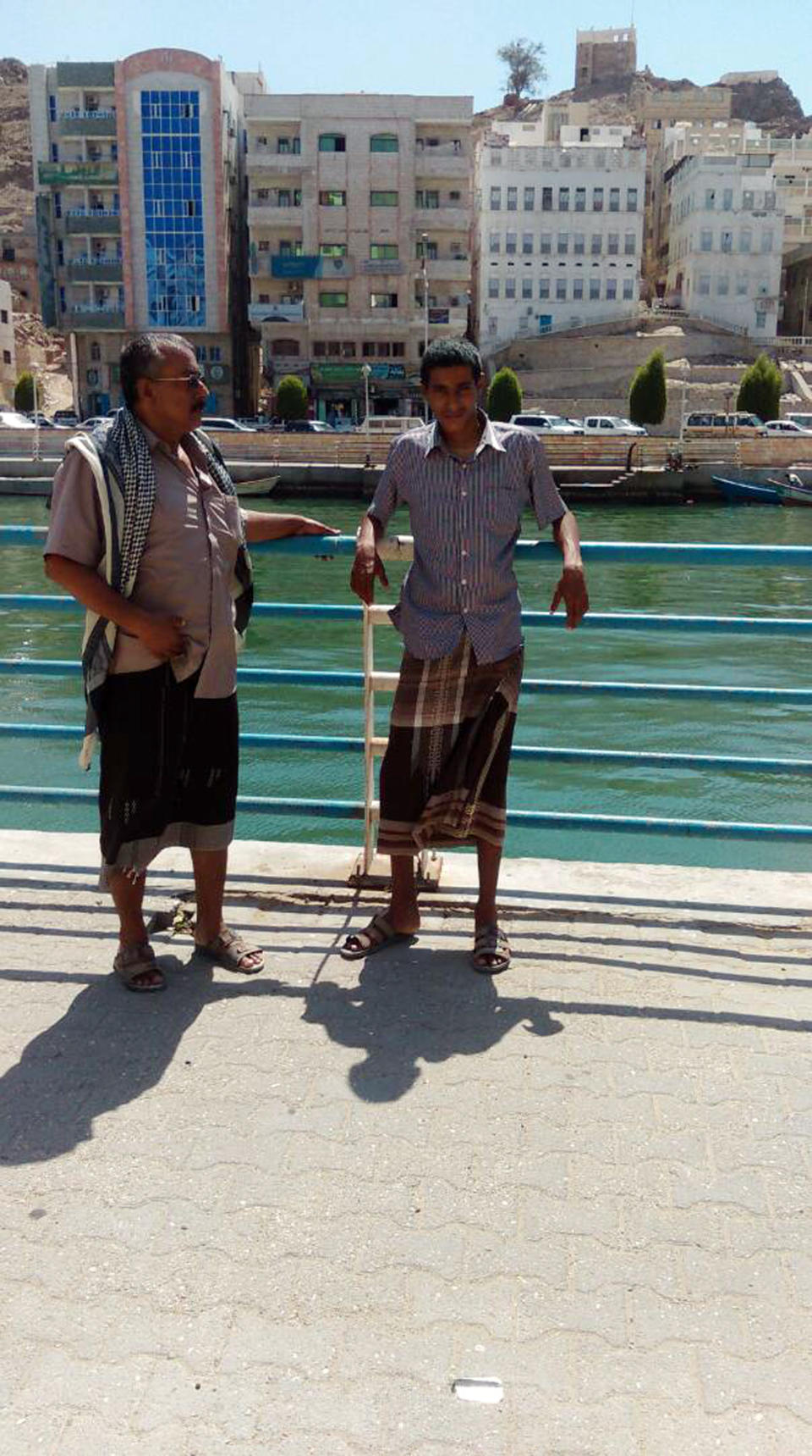 This undated family photo shows Abdullah Saleh Elwiya, right, and his father Saleh Elwiya in the coastal city of Mukalla southern Yemen, months before his ordeal, when he was lured by al-Qaida prompting a frantic search by his family as US drones flew overhead in the mountains of southern Yemen. (Saleh family via AP)