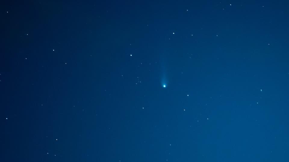 a fuzzy green comet in the night sky