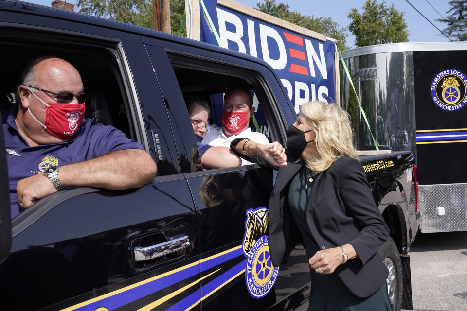Jill Biden, right, wife of Democratic presidential candidate former vice president Joe Biden, greets Teamsters Union members Roger Tavers, left, and Matt Lortie, second from right, both of Manchester, N.H., as she bumps elbows with an unidentified person, center, during a campaign stop, Wednesday, Sept. 16, 2020, in Manchester. (AP Photo/Steven Senne)
