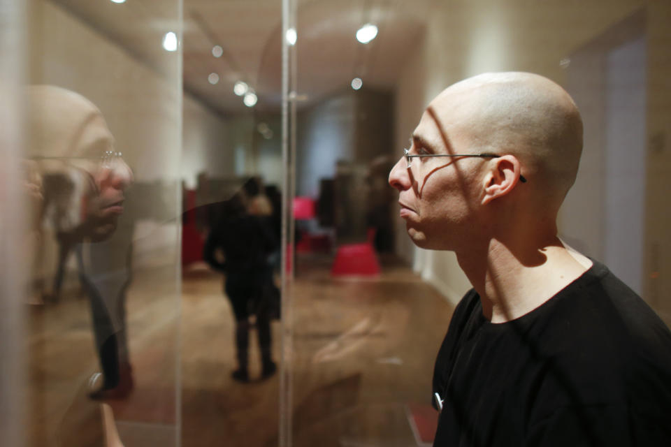 FILE - In this March 22, 2013 file photo, Israeli Ido Porat prepares to be the first person acting as the 'Jew in a glass box', on the first day of the exhibition "The Whole Truth … everything you always wanted to know about Jews" at the Jewish Museum in Berlin. Nearly 70 years after the Holocaust, there is no more sensitive an issue in German life as the role of Jews. With fewer than 200,000 Jews among Germany's 82 million people, few Germans born after World War II know any Jews or much about them. To help educate postwar generations, the Jewish Museum in Berlin offers a Jewish man or woman to sit inside a glass box for two hours a day through August to answer visitors' questions about Jews and Jewish life. The base of the box asks: “Are there still Jews in Germany?” "A lot of our visitors don't know any Jews and have questions they want to ask," museum official Tina Luedecke said. "With this exhibition we offer an opportunity for those people to know more about Jews and Jewish life." But not everybody thinks putting a Jew on display is the best way to build understanding and mutual respect. (AP Photo/Markus Schreiber, File)