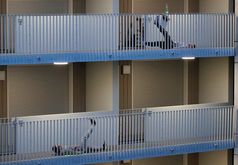 Residents exercise on their balconies following fitness trainers in Nantes