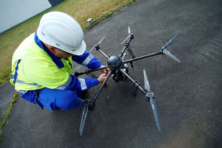 A worker maintains a drone which is used to survey high-voltage power lines of electric company Westnetz near Wilnsdorf, Germany, July 11, 2018. REUTERS/Ralph Orlowski