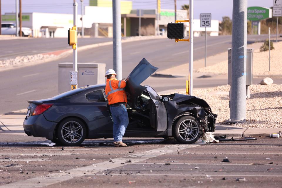 A man places a damaged part of a car that was torn off when it was struck by a car suspected of smuggling undocumented migrants on the morning, on March 17 on North Mesa Street near Resler Drive in West El Paso.