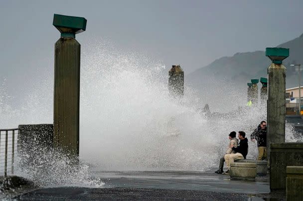 PHOTO: People watch as waves crash into a seawall in Pacifica, Calif., Jan. 6, 2023. (Jeff Chiu/AP)