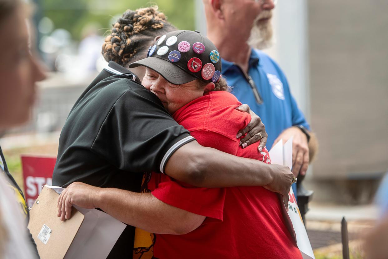 Jamey Gunter, right, with Asheville Food and Beverage Workers United and Union of Southern Service Workers, is hugged by Nichel Dunlap Thompson, an organizer with Charlotte-Metrolina Labor Council, after Gunter’s speech in Thursday’s rally.
