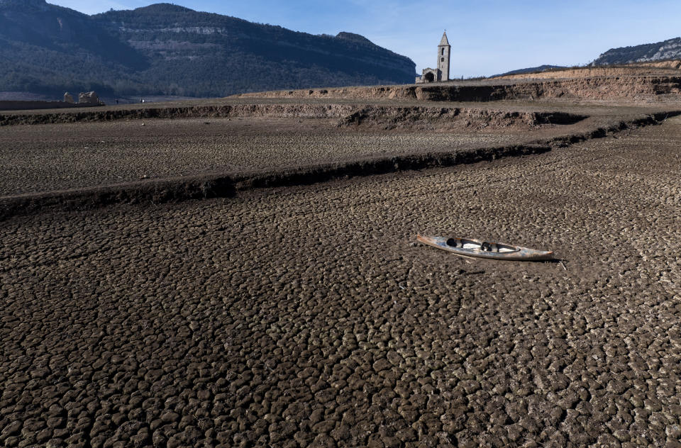 An abandoned kayak lies on the cracked ground at the Sau reservoir, which is only at 5 percent of its capacity, in Vilanova de Sau, about 100 km (62 miles) north of Barcelona, Spain, Friday, Jan. 26, 2024. The northeastern region of Catalonia is one of the two worst-hit regions in a two-year-plus drought affecting most of Spain. Reservoirs in the eastern coastal part of Catalonia are below 16% of their capacity, less than half the current national average, and the region is on the point of declaring a drought emergency and introducing more water restrictions for houses, farmers and industry. (AP Photo/Emilio Morenatti)