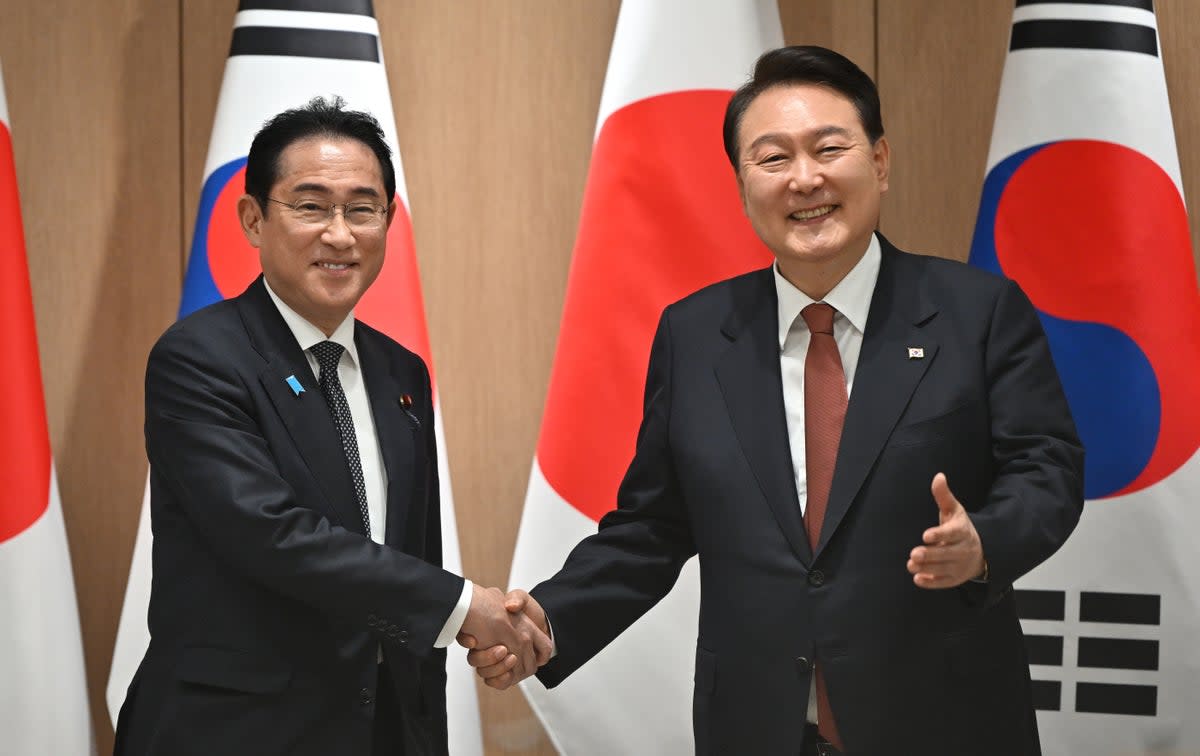 Yoon Suk Yeol shakes hands with Fumio Kishida (left) during their meeting at the former’s presidential office  (Getty)