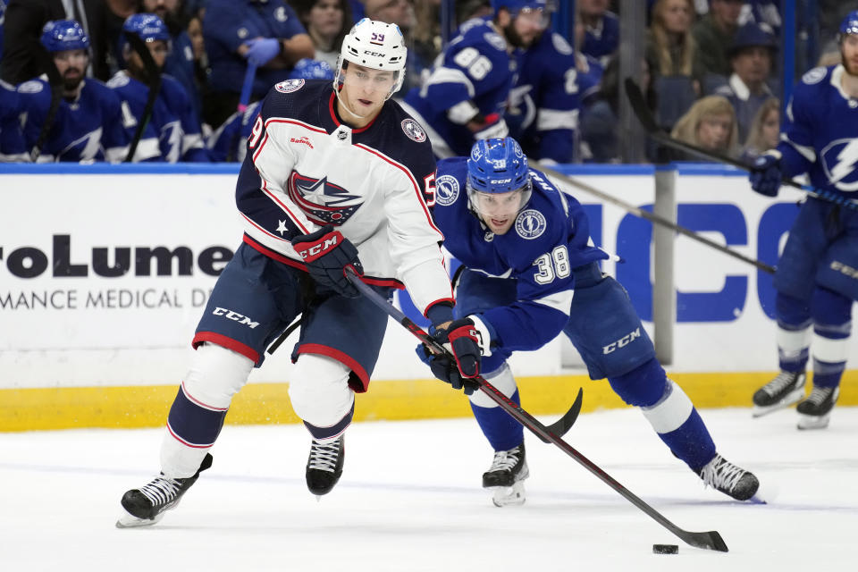 Columbus Blue Jackets right wing Yegor Chinakhov (59) steals the puck from Tampa Bay Lightning left wing Brandon Hagel (38) during the first period of an NHL hockey game Thursday, Dec. 15, 2022, in Tampa, Fla. (AP Photo/Chris O'Meara)