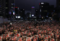 In this Aug. 15, 2019 photo, protesters hold candles and signs during a rally denouncing Japanese Prime Minister Shinzo Abe and also demanding the South Korean government to abolish the General Security of Military Information Agreement, or GSOMIA, an intelligence-sharing agreement between South Korea and Japan, in downtown Seoul, South Korea. South Korea and Japan have locked themselves in a highly-public dispute over history and trade that in a span of weeks saw their relations sink to a low unseen in decades. The letters read "No Abe." (AP Photo/Lee Jin-man)