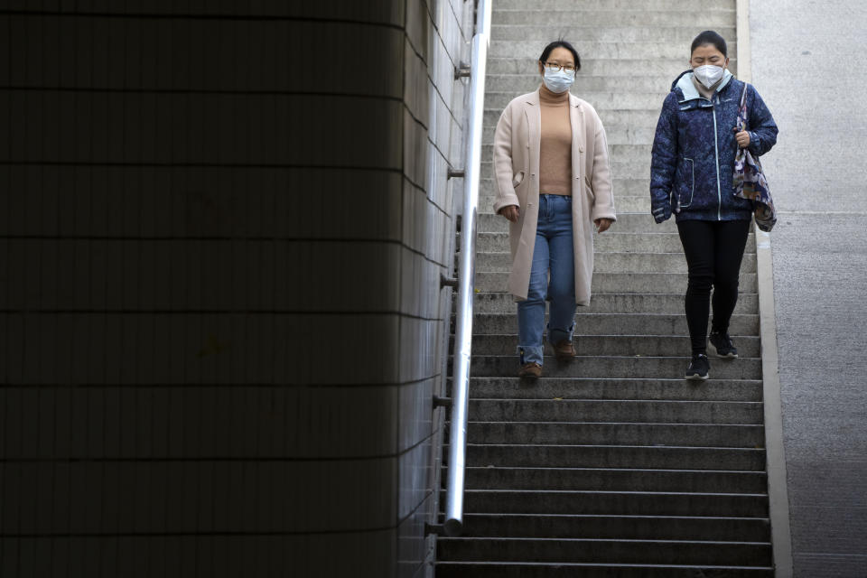 Commuters wearing face masks walk through a pedestrian underpass in Beijing, Wednesday, Nov. 16, 2022. Chinese authorities locked down a major university in Beijing on Wednesday after finding one COVID-19 case as they stick to a "zero-COVID" approach despite growing public discontent. (AP Photo/Mark Schiefelbein)