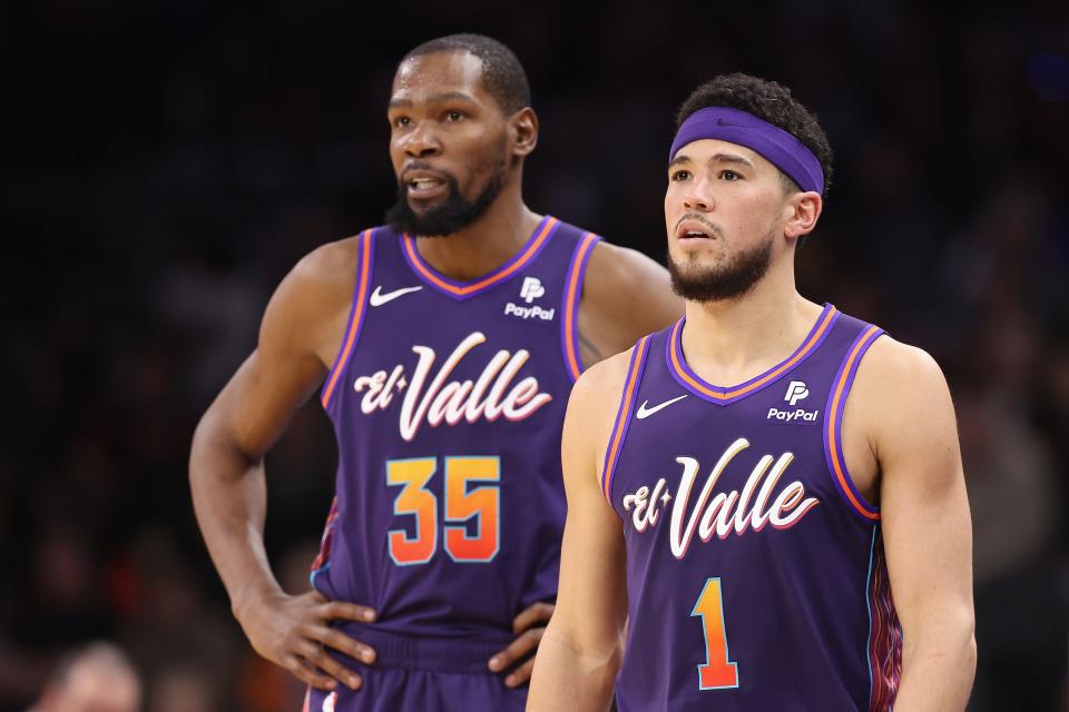 Devin Booker #1 and Kevin Durant #35 of the Phoenix Suns on the court during the first half of the NBA game against the Charlotte Hornets at Footprint Center on Dec. 29, 2023, in Phoenix.