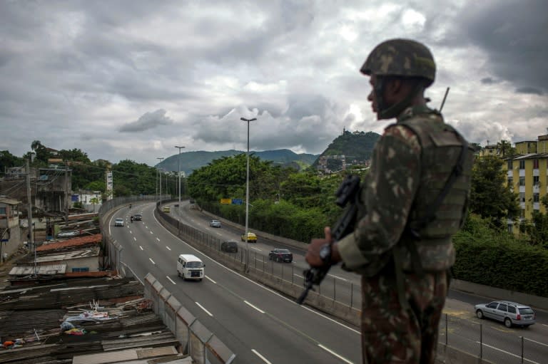 A Brazilian Army soldier stands guard over the "Linha Amarela" (yellow line) road during a joint operation at "Cidade de Deus" (City of God) favela in Rio de Janeiro, Brazil, as Brazil prepares to send in troops to battle gang violence