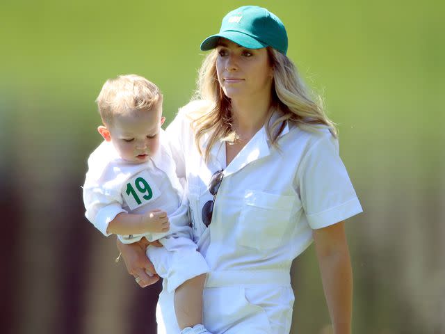 <p>Andrew Redington/Getty</p> Jillian Stacey and son Logan James during the Par 3 Contest prior to the Masters on April 10, 2019 in Augusta, Georgia.