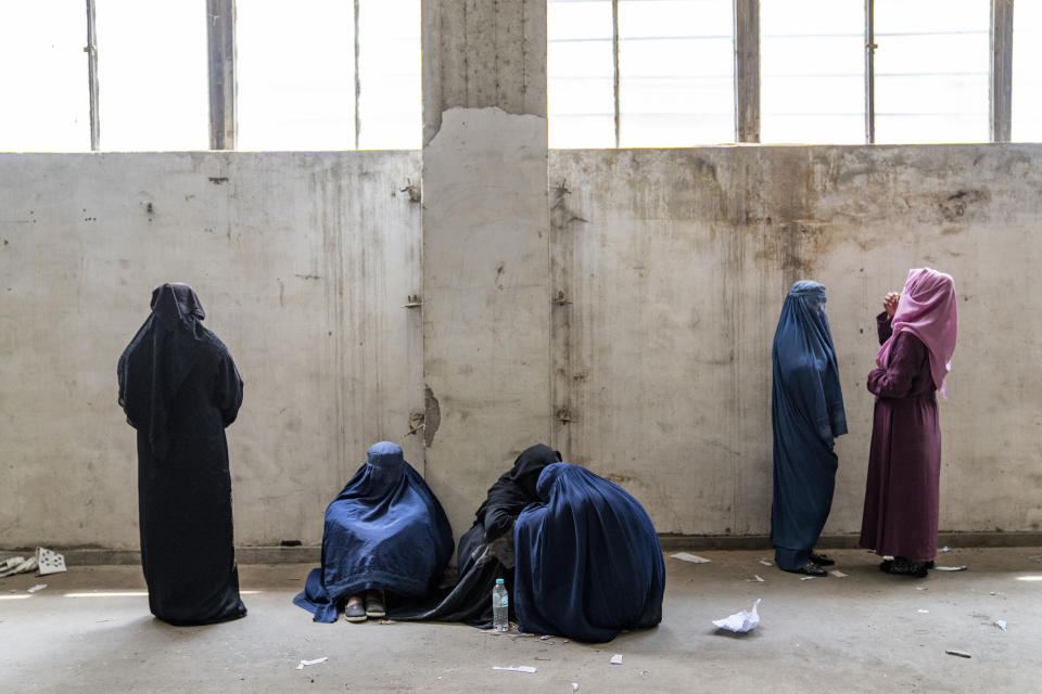 Afghan women wait to receive food rations distributed by a humanitarian aid group, in Kabul, Afghanistan, Tuesday, May 23, 2023. (AP Photo/Ebrahim Noroozi)