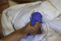 A healthcare worker attends to a COVID-19 patient in an intensive care unit (ICU) at Na Bulovce hospital in Prague, Czech Republic, Thursday, Oct. 1, 2020. A record surge of new coronavirus infections in the Czech Republic in September has been followed by a record surge of those hospitalized with COVID-19. The development has started to put the health system in the country under serious pressure for the first time since the pandemic hit Europe. (AP Photo/Petr David Josek)