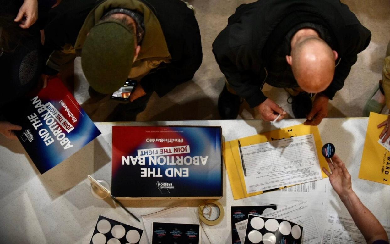 Supporters sign an initiative petition in support of a ballot measure that would legalize abortion up to the point of fetal viability in Missouri. during an event on Feb. 6, 2024, in Kansas City hosted by Missourians for Constitutional Freedom.