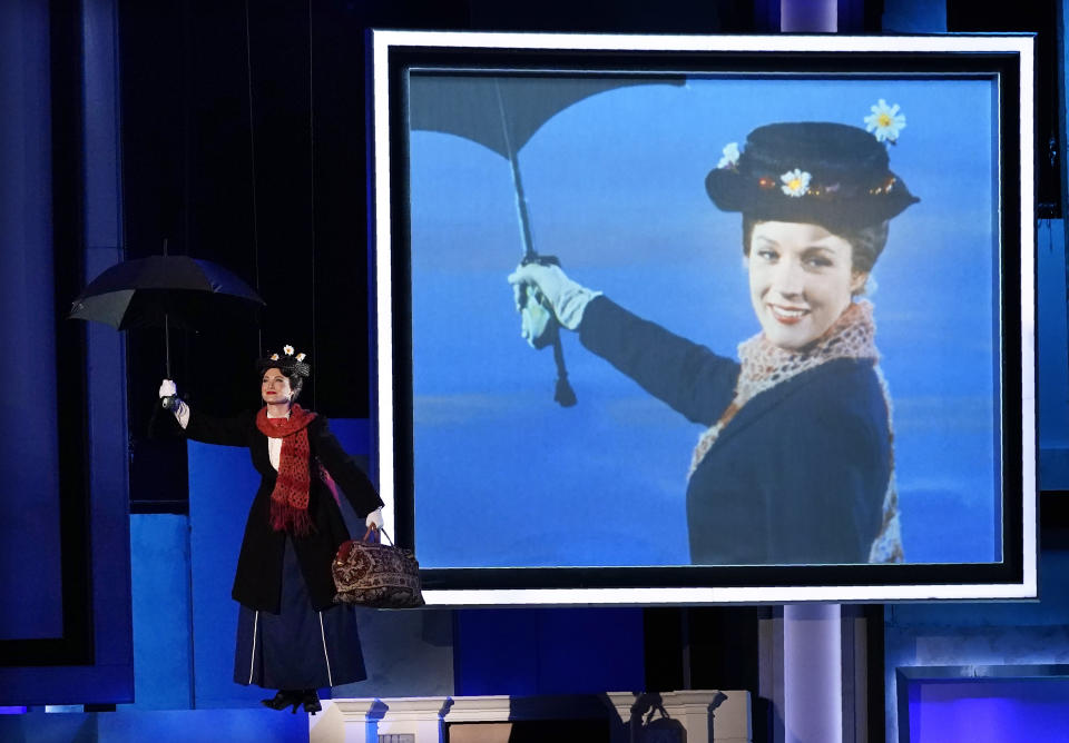 A performer dressed as the movie character Mary Poppins flies past a picture of actor Julie Andrews portraying Mary Poppins in the 1964 film, at the 48th AFI Life Achievement Award Gala honoring Andrews, Thursday, June 9, 2022, at the Dolby Theatre in Los Angeles. (AP Photo/Chris Pizzello)