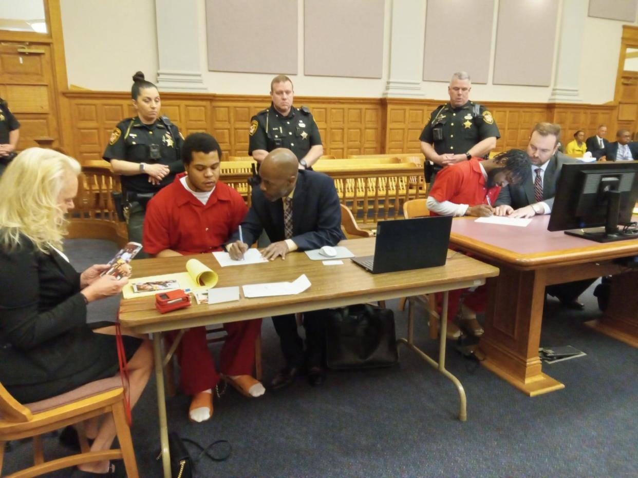 Criminal defendants Braylen J. Smallwood, at left, and Trezjon R. Allen, at right, sign court documents at their sentencing on Tuesday, when both were ordered to spend 20 to 25.5 years in prison for shooting at police detectives and other crimes.