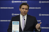 Florida Gov. Ron DeSantis holds up a flyer for a public service campaign as he speaks during a news conference, Monday, Aug. 3, 2020, at the Broward Health Corporate Office in Fort Lauderdale, Fla. On Friday, the governor's office released a video promoting "One Goal One Florida," a public service campaign that also urges Floridians to keep their distance and wear masks as a way to lower the risk of coronavirus infections. (AP Photo/Wilfredo Lee)