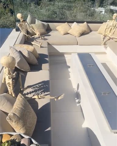 <p>Chrissy Teigen/Instagram</p> Chrissy Teigen's skeletons sitting by the fire.