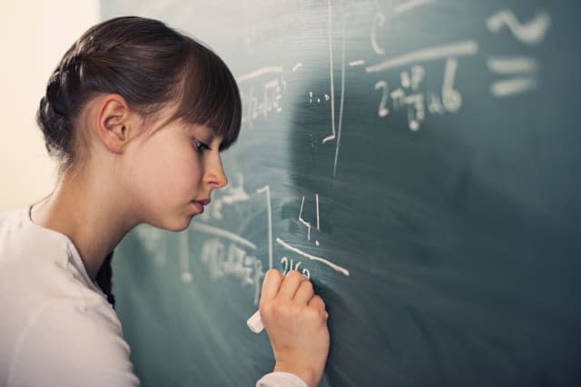 Little girl writing difficult mathematics equations