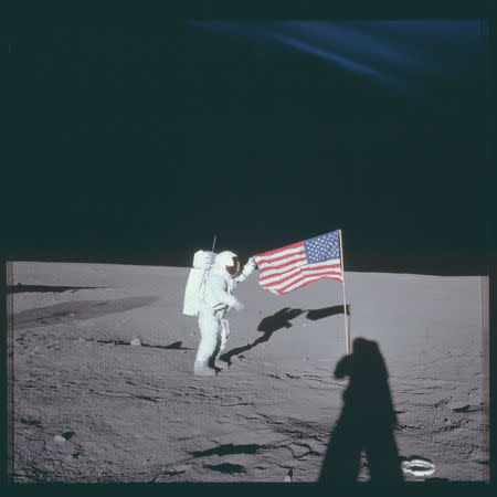 Astronaut Charles "Pete" Conrad Jr., Apollo 12 commander, stands beside the United States flag on the lunar surface during the first extravehicular activity November 16, 1969. REUTERS/NASA/Handout
