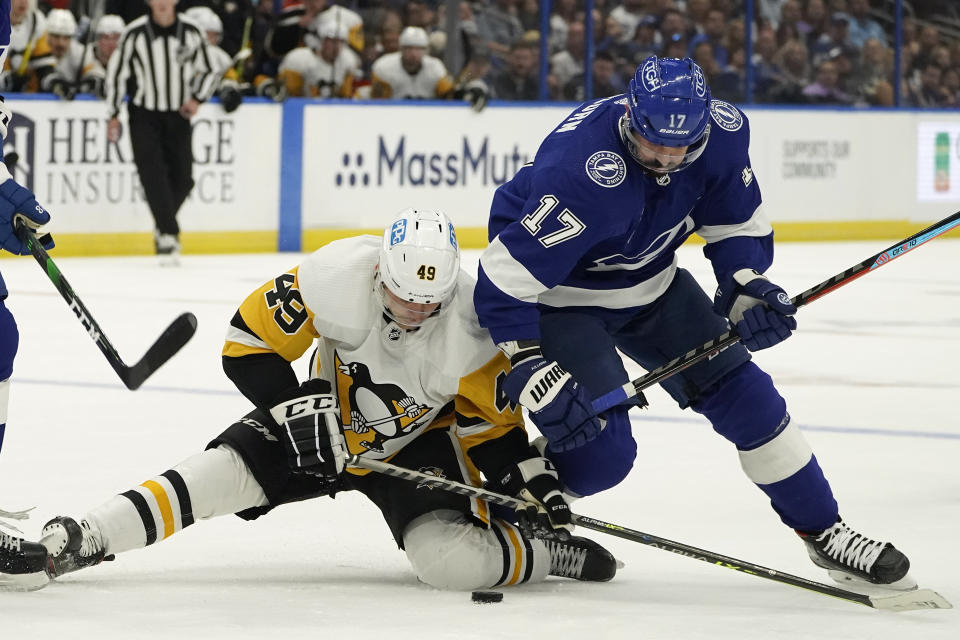 Tampa Bay Lightning left wing Alex Killorn (17) knocks down Pittsburgh Penguins center Dominik Simon (49) as they chase a loose puck during the first period of an NHL hockey game Tuesday, Oct. 12, 2021, in Tampa, Fla. (AP Photo/Chris O'Meara)