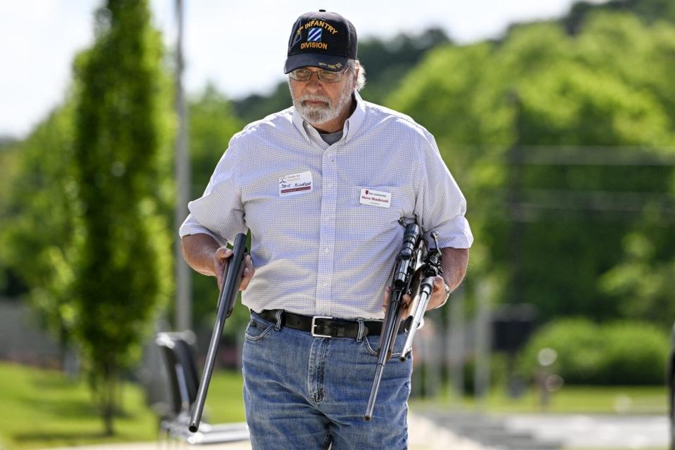 Volunteer Steve Mushrush carries rifles from a car to be dismantled at the Guns to Gardens event at the First Community Church North ib June 11.