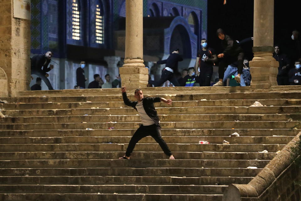 A Palestinian hurls stones at Israeli police during clashes at the compound that houses Al-Aqsa Mosque, known to Muslims as Noble Sanctuary and to Jews as Temple Mount, amid tension over the possible eviction of several Palestinian families from homes on land claimed by Jewish settlers in the Sheikh Jarrah neighbourhood, in Jerusalem's Old City, May 7, 2021. (Ammar Awad/Reuters)